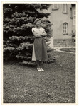 Hedi Politzer stands in a garden wearing a traditional Austrian dress.