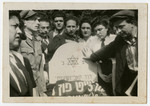 Displaced persons gather around the grave of Jewish policeman, David Kabesicki in Feldafing.