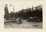 A survivor stands looking out over the charred corpses at Leipzig-Thekla.