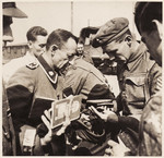 British soldiers inspect the documents of former SS guards at Bergen-Belsen concentration camp.