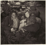 Female survivors lie, covered in blankets, on the floor of a barracks in the Bergen-Belsen concentration camp.