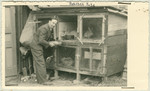 Either a staff member or patient tends rabbits kept in a hutch at the Hartheim euthanasia facility.