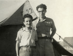 Dario Navarra and Giacomo Mattarazzi pose in front of a tent in a Cyprus refugee camp.