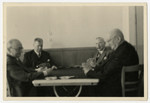 A group of men play a game of cards.

Emil Gundelfinger is second from the right, smoking a cigar.