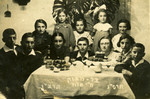 Children gather around a table to celebrate the bar mitzvah of Lonek (Leon) Halberstadt in Krasnik Poland.