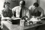 Three people work in the office of the Jewish Agency for Palestine in the Stuttgart displaced persons' camp.