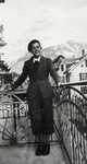 Heinz Mayer stands on the porch of the Orthodox Zionist children's home in Engelberg, Switzerland in front of a view of the Alps.