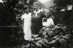 A mother and her two daughters pose in a wooded area near their home.