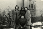 Friends pose in front of a building in the Bergen-Belsen displaced persons' camp.