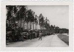 An American convoy leads survivors [probably of Buchenwald] out of the camp.