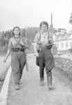 Female partisans, Sara Ginaite amd Ida Vilenchiuk, walk down a street of Vilna during its liberation.