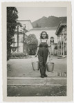 Eva Weinberger carries two milk pails in a kibbutz hachshara near Bern.