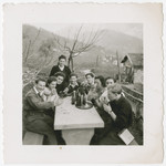 A group of young people enjoys a drink while on an excursion through the Swiss countryside.