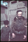 Close-up portrait of a middle-aged man with a beard and armband and a young boy [possibly in Kozienice].