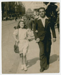 Fanny Fogel walks downn a street in postwar Brussels arm in arm with her father Jacob.