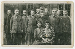 Group portrait of survivors, many still in uniform, in the Dachau concentration camp.