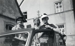 Three German-Jewish children peek out of the open roof of an automobile.