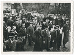 Members of the SA arrest Jewish men from Oldenburg and march them through the streets as bystanders look on.