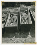 Bodies dug up from a mass grave lie in coffins prior to reburial.