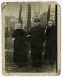 Three elderly Jews pose in the woods behind the Pensjonat Zacheta, outside the Otwock ghetto.