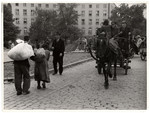 Polish civilians carry bundles and travel in horse-drawn carriages during the siege of Warsaw.