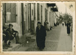 Jews sit on doorsteps and walk down a street of what probably is the Deblin-Irena ghetto.