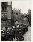 German soldiers march through a street in Munich after their surrender and capture.