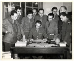 Members of the 4th Communications Unit, a counter-intelligence unit, study the German newspapers it was responsible for publishing.