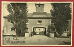 Photograph showing the entrance to the Dachau concentration camp pasted into an album presented to Lt.