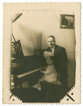 Maurice Reinberg sits by the piano with his small daughter Halina.