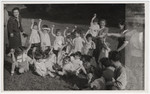 Young children [probably from Lindenfels] hold up pieces of fruit they received during an outdoor excursion.