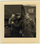 A member of the Frankfurt Jewish GI Council poses with a Jewish displaced person holding his young child.