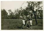 Johanna and Irma Landman pose in a grassy field with their aunts and cousins.