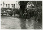 American soldiers stand guard over recently captured German prisoners.