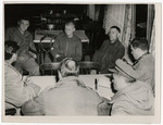 United States soldiers listen intently as political prisoners tell their story.