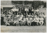 A group of displaced persons poses for a group photograph, possibly at a monastery near Munich.