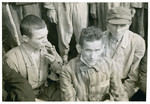 A close-up of three survivors at a gathering in the Langenstein-Zwieberge concentration camp.