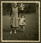 Rosian Bagriansky stands outside holding hands [with her nanny].