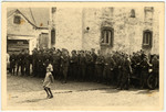 A young girl is pictured in front of a group of German soldiers.