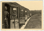 Members of the German military look out the door of a train.