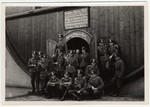 German soldiers pose in front of a giant wine barrel.