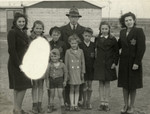 Portrait of the Birnbaum family in the Westerbork transit camp wearing Jewish stars on the street where they lived.