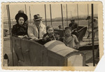 A Bulgarian Jewish family goes for a merry-go-round ride in an amusement park during the war.