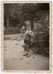 A young Jewish boy, Misha Avramoff, plays a toy trumpet while wearing a  Bulgarian officer's hat in Ruse, Bulgaria.