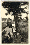 Pola Zawierucha with her daughter Regina, seated on a tree strump, in the Fohrenwald displaced persons camp.