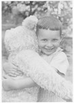 Hans Frank Rosenbaum hugs a giant stuffed teddy bear.
