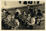 Children in the Nos Petits Jewish kindergarten sit in a classroom holding small xylophones.