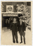 Willy Bogler (left) and Saul Zohar (right) pose in front of the entrance of a building with a large sign "Exodus 1947."