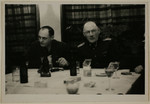 Two SS officers gather for drinks in a hunting lodge.