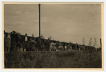 Displaced persons stand on the train platform.

Original Caption reads: DPs detrained on the platform.